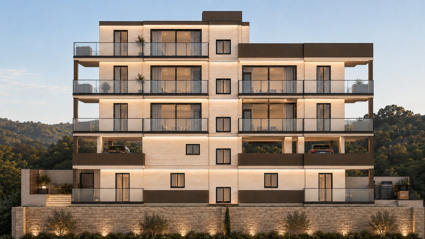 The front of Aurea Residence at dusk, its balconies and stone façade lit from within